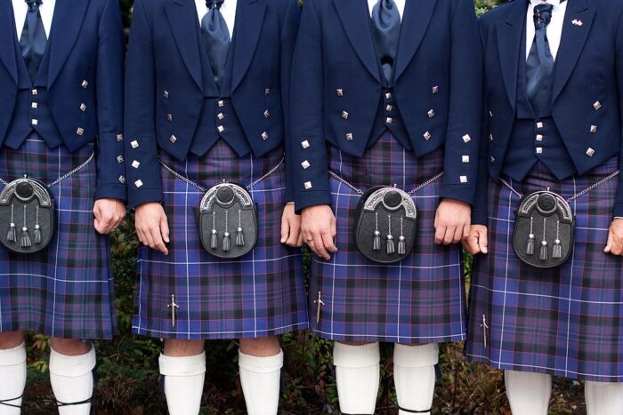 Four men in formal, Scottish kilts.